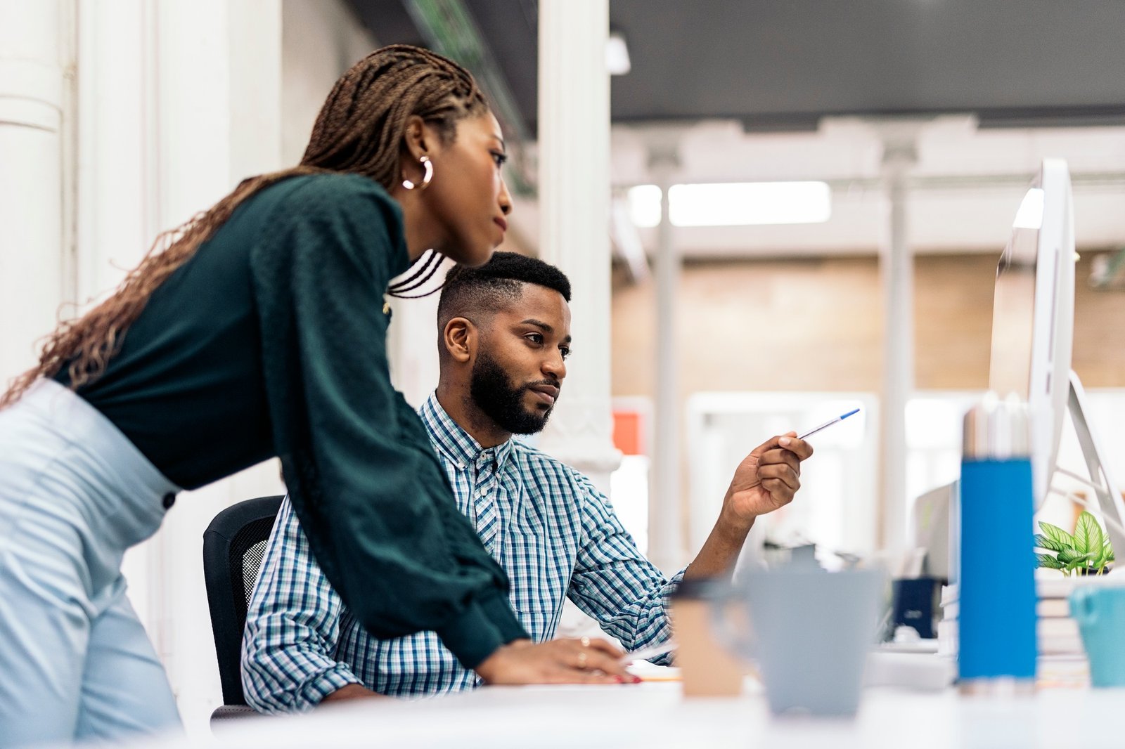 Two colleagues reviewing work together on a computer in an office