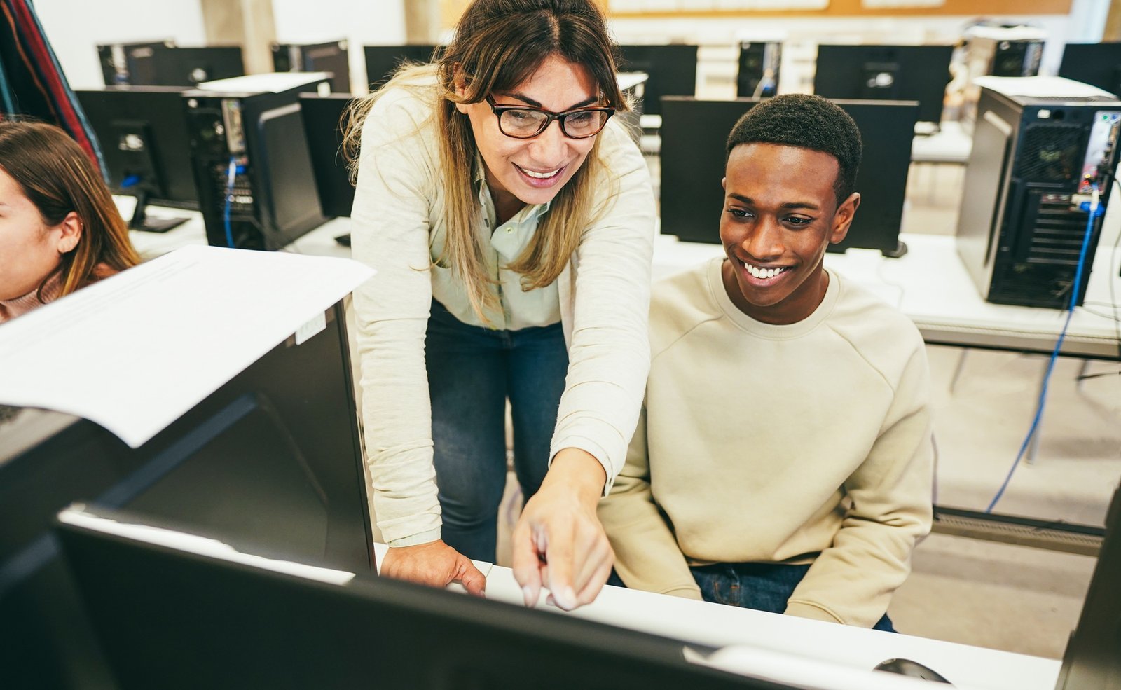 A mentor working with a young founder at a computer