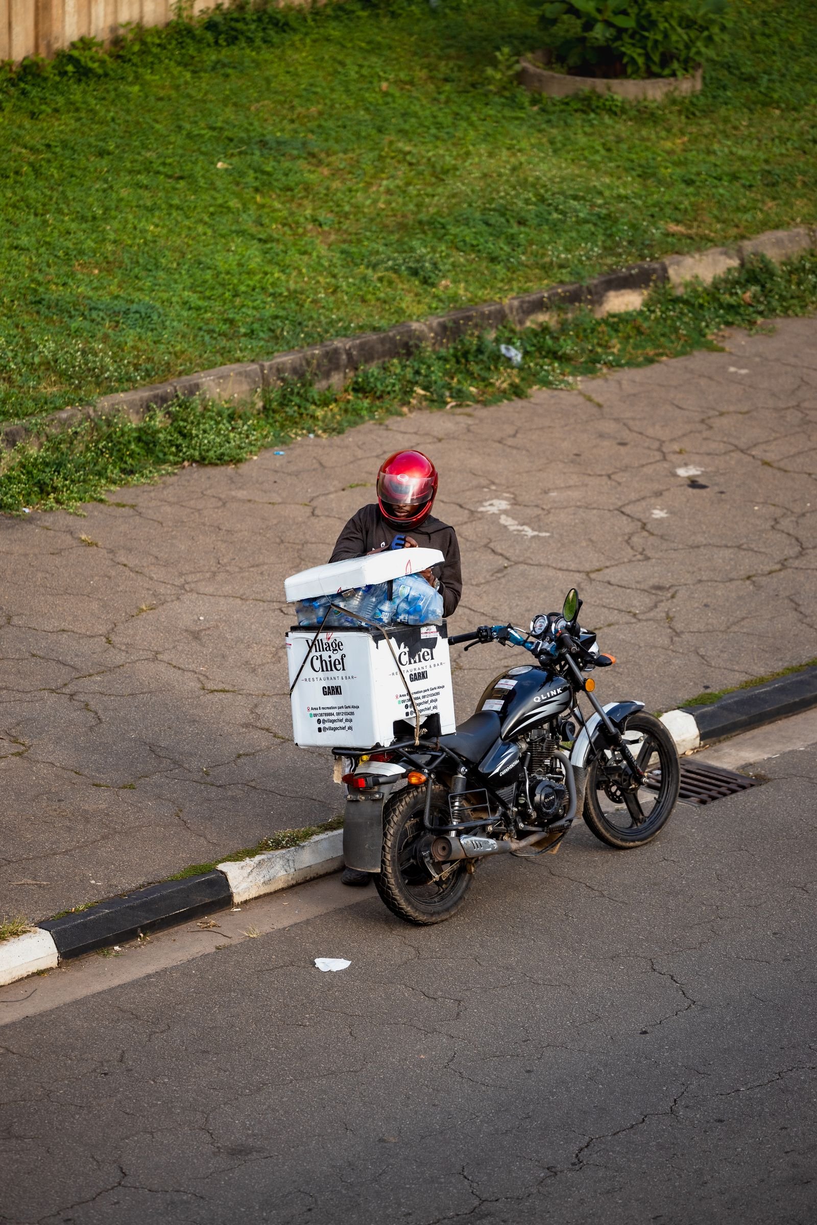 A delivery rider with a cargo box on a motorcycle in Abuja, Nigeria