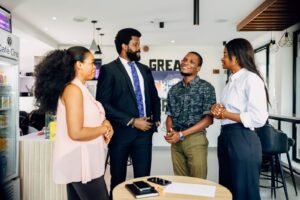 Four professionals talking in a casual office meeting in Lagos, Nigeria