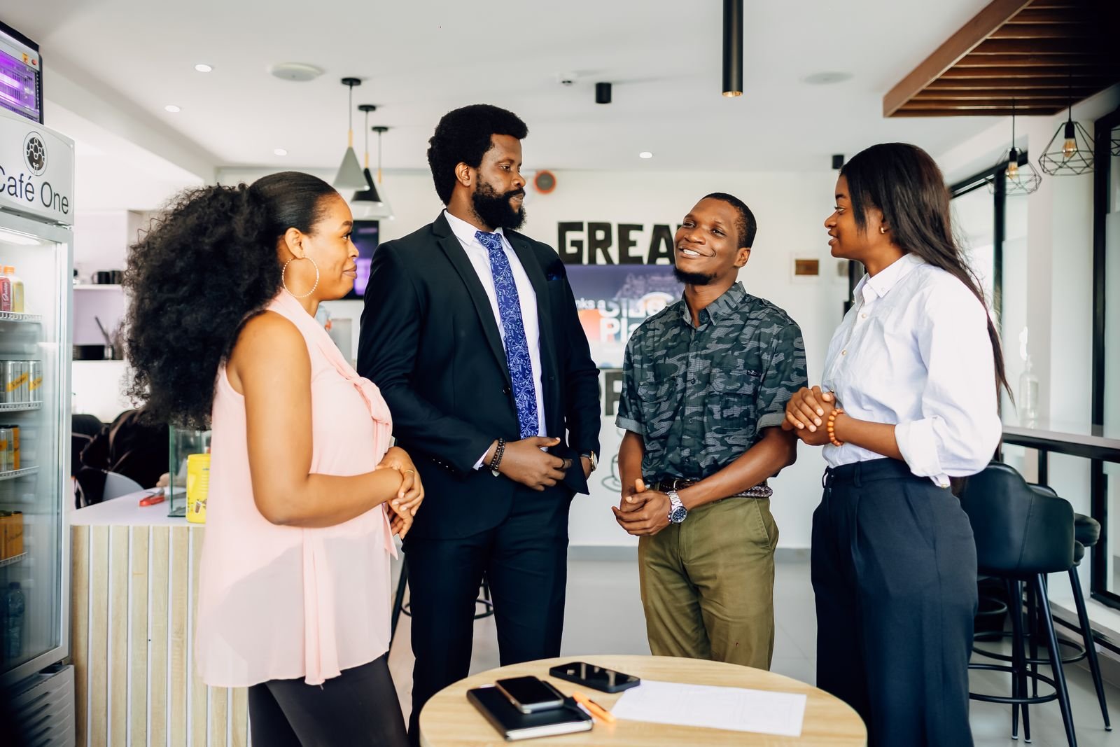Four professionals talking in a casual office meeting in Lagos, Nigeria