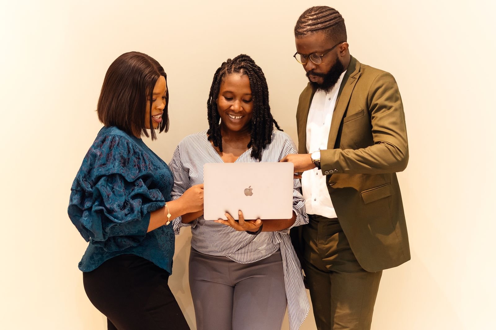 Three colleagues looking at a laptop together in an office in Lagos, Nigeria