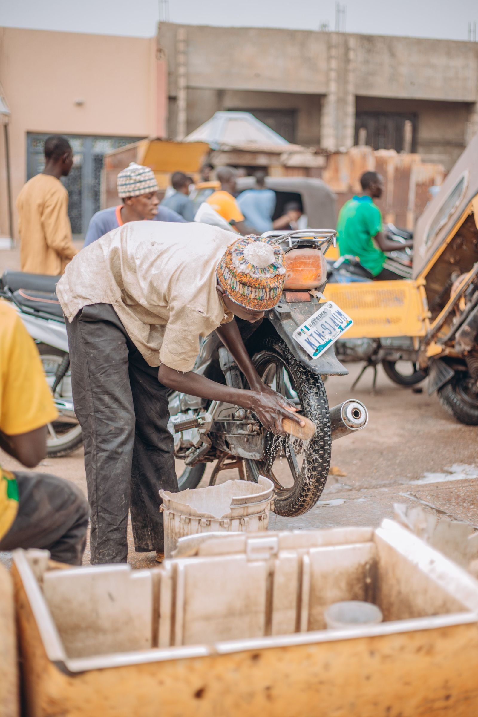 Mechanics repairing motorcycles at a busy roadside workshop