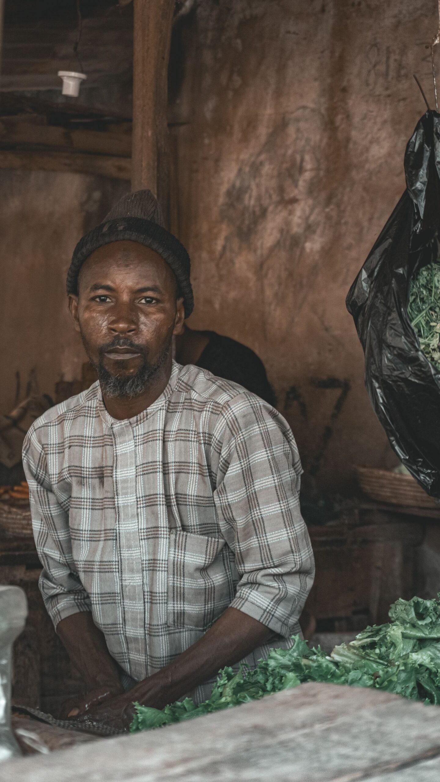 A vendor selling fresh produce at an agricultural market in Kano, Nigeria