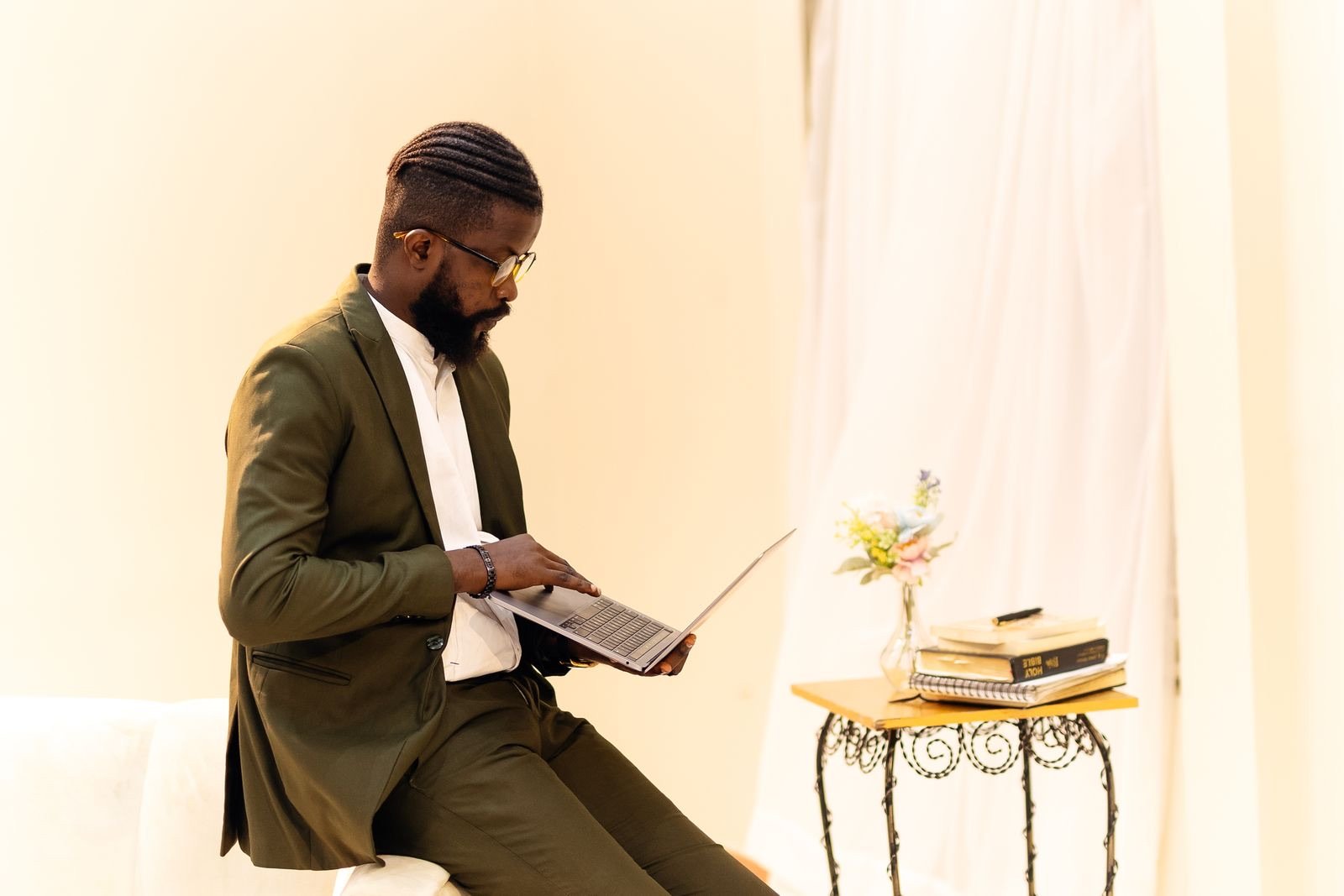 A professional in a green suit reviewing notes on a laptop in a Lagos office